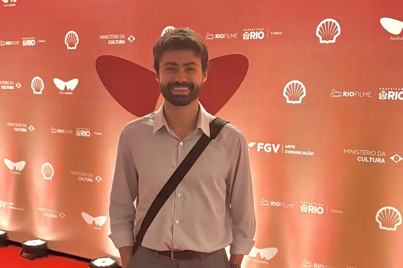 Carlos Macedo diante do painel de um evento cultural no Rio de Janeiro