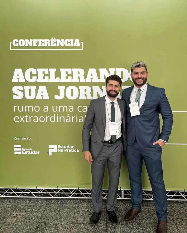 Carlos Macedo e Allan Turano diante do painel de uma conferência da Fundação Estudar